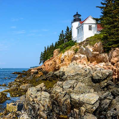 hillside lighthouse overlooking the rocky coast in Maine